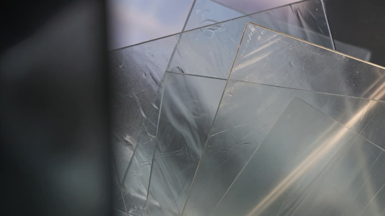 Layered translucent glass panes with soft light, suggesting clarity and protection